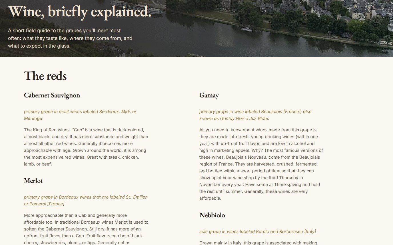 The Vin de Vin learning page today: a banner reading Wine, briefly explained over a Mosel river town, above a two-column guide headed The reds, each grape with the wines it is labeled as and a short description